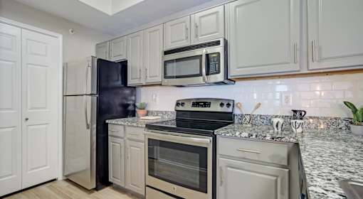 A kitchen with white cabinets and appliances.
