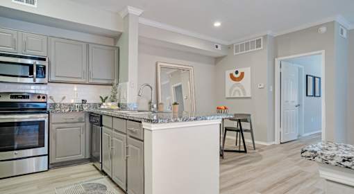 A modern kitchen with a white island and stainless steel appliances.