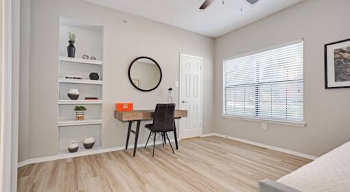 A room with a desk and chair in it.
