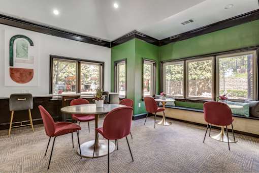 A room with green walls and a table with red chairs.