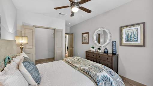 A bedroom with a large bed and a ceiling fan.