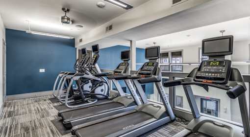 A gym with treadmills and elliptical machines.