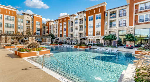 A large swimming pool in front of apartment buildings.