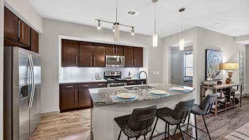 A modern kitchen with a refrigerator, sink, and dining area.