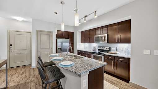 A kitchen with brown cabinets and a granite countertop.