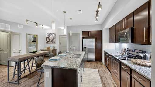 A modern kitchen with dark wood cabinets and stainless steel appliances.