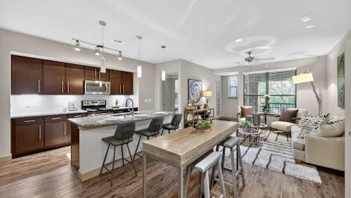 A modern kitchen with a dining area and a living room.