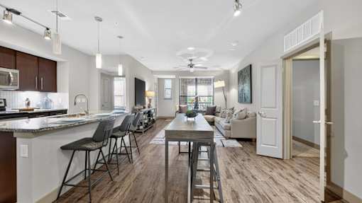 A modern kitchen with dark wood floors and white walls.