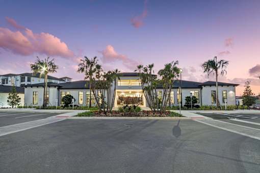 A modern building with a parking lot in front of it.