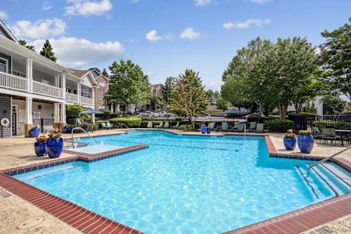 A large swimming pool surrounded by a red brick border.