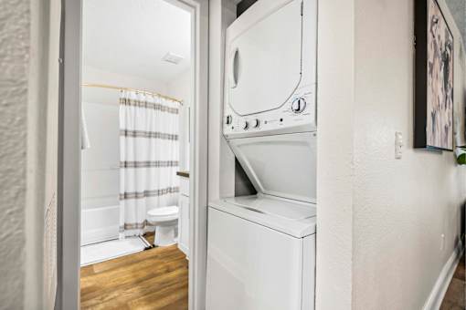 A white washing machine is in a small laundry room.
