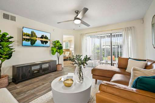 A living room with a flat screen TV mounted on the wall.