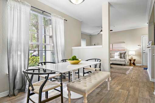 A dining room with a white table and chairs.