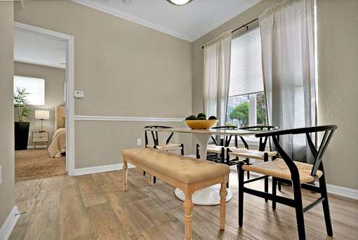 A dining room with a bench, chairs, and a table.