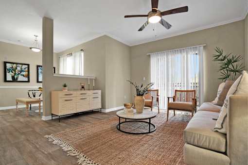 A living room with a ceiling fan and a rug on the floor.