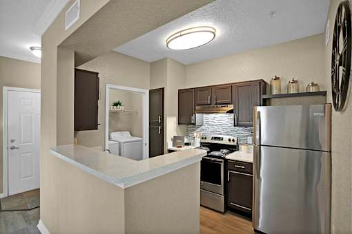 A kitchen with a refrigerator, oven, and microwave.