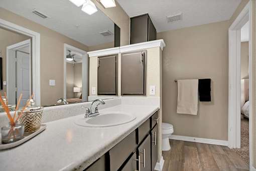 A bathroom with a white sink and a white toilet.