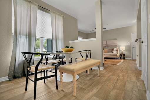 A modern dining room with a wooden table and chairs.