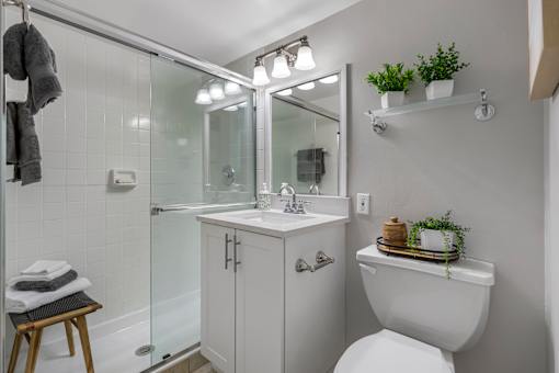 A white toilet sits next to a white sink in a bathroom.