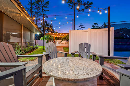 A patio with a table and chairs is set up for an evening outside.