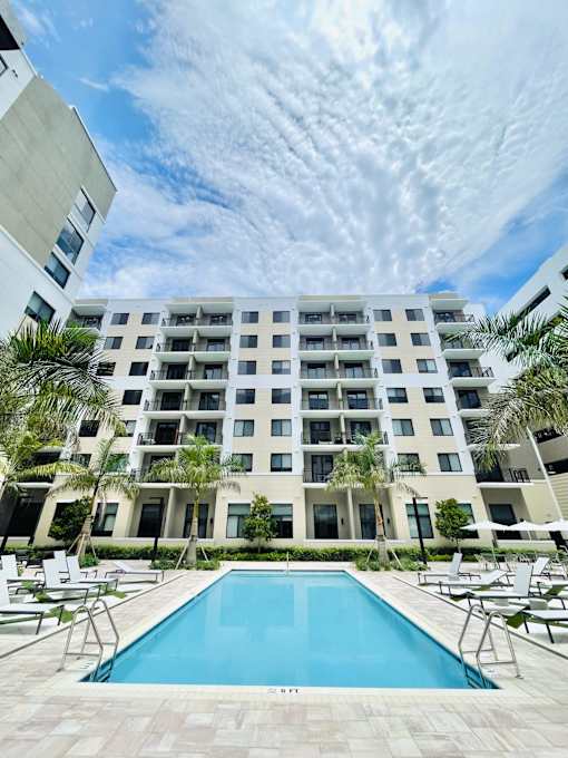 A large white building with a pool in front.