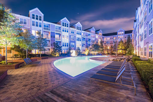an apartment building with a pool at night