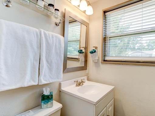 A white towel hangs on a towel rack in a bathroom.