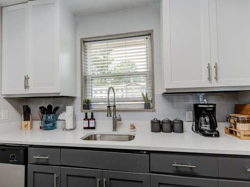 A kitchen with black cabinets and a white countertop.