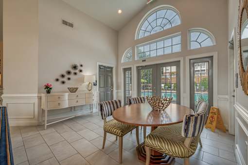 A dining room with a round table and striped chairs.