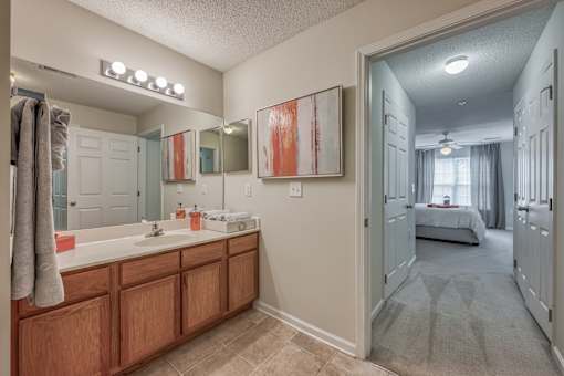 A bathroom with a large mirror and a wooden vanity.
