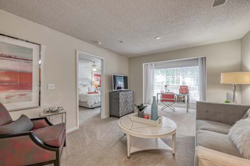 A living room with a red couch and a white coffee table.