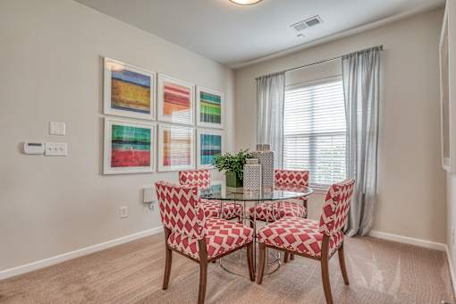 A dining room with a table and chairs.