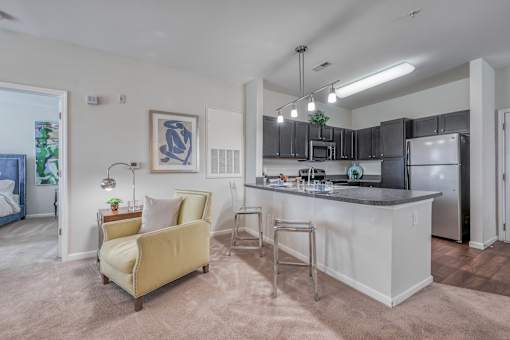 A kitchen with a white island and a yellow chair.