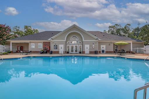 A large swimming pool in front of a house.