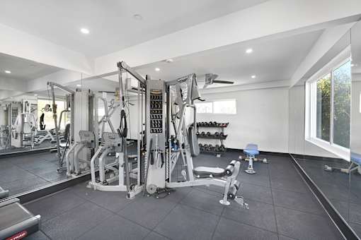 A well lit gym with a variety of equipment.