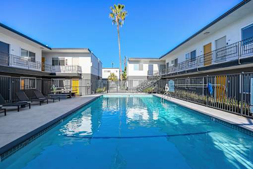 A pool in the middle of a courtyard surrounded by buildings.