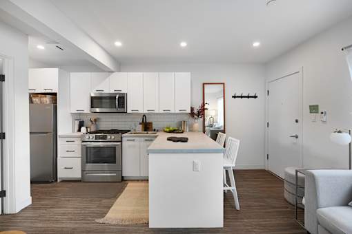 A modern kitchen with white cabinets and stainless steel appliances.
