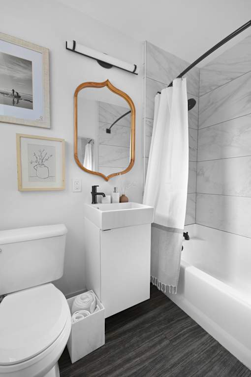 A bathroom with a white toilet, a white sink, and a white shower curtain.