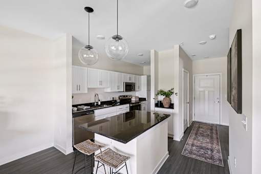 A modern kitchen with a black countertop and white cabinets.