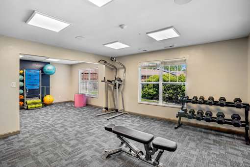 A gym room with a bench, weights, and exercise equipment.