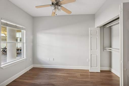 A room with a ceiling fan and a door.