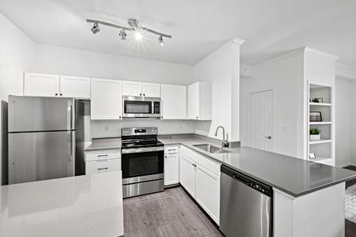 A modern kitchen with stainless steel appliances and white cabinetry.