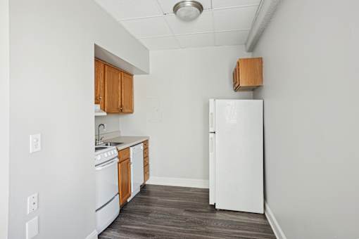 A kitchen with white appliances and wooden cabinets.