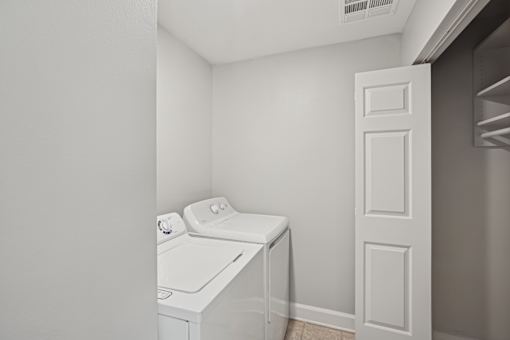 A white washing machine in a small laundry room.