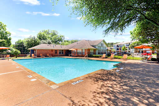 A large outdoor swimming pool with a building in the background.
