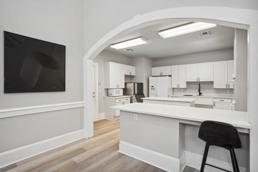 an open kitchen and living room with white cabinets and a white counter top