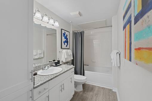 A bathroom with a white sink and a white toilet.