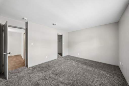 A room with a grey carpet and white walls.