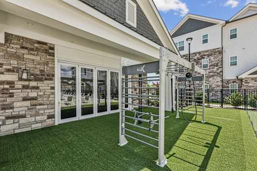 A patio with a metal railing and a green lawn.