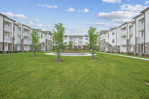 A grassy area in front of apartment buildings.